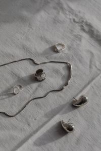 Kaboompics - Silver Jewelry Flat Lay on White Tablecloth