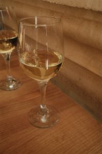 Kaboompics - Close-Up of White Wine Glasses with Reflections on Wooden Table