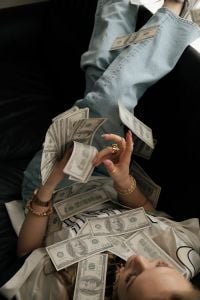 Kaboompics - Woman Lying on a Sofa Covered With Cash