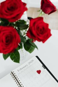 Kaboompics - Red Rose Bouquet Framing February Planner and Felt Heart, Vertical Flat Lay
