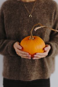 Kaboompics - Women's hands in sweater are holding pumpkin