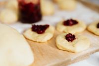 Kaboompics - Cherry-Topped Paczki Dough on a Flour-Dusted Wooden Board