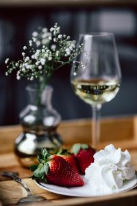Kaboompics - Strawberries with cream and glass of white wine on wooden tray