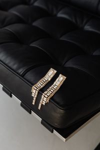 Kaboompics - Gold Crystal Drop Earrings on a Black Barcelona Chair