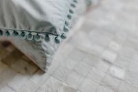 Kaboompics - Close-Up of Gray Sofa Cushion with Pom-Pom Fringe Trim