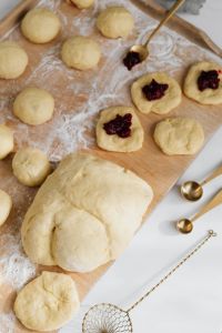 Kaboompics - Close-Up of Cherry-Filled Pączki Dough and Gold Measuring Spoons