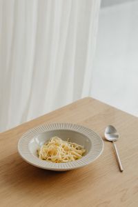 Kaboompics - Bowl of Homemade Noodles with Spoon on a Wooden Table
