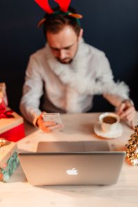 Kaboompics - Designer in Reindeer Antlers Using a Smartphone at a Christmas Desk