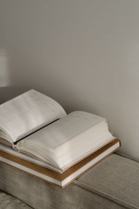 Kaboompics - Open Planner and Stacked Books on a Sofa, Neutral Home Office Background