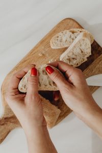 Kaboompics - Hands Tearing Rustic Bread into Pieces