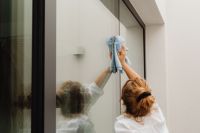 Kaboompics - Woman Cleaning a Large Glass Window with a Cloth