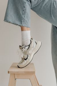 Kaboompics - Close-Up of Wide-Leg Denim Hem and White Sock against Neutral Studio Background