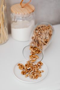 Kaboompics - Wood-Lidded Glass Jar of Wheat Flour beside Walnuts on a Neutral Counter