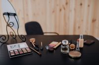 Kaboompics - Beauty Product Styling with Lipstick, Face Powder, Perfume and Brushes on a Black Vanity