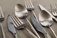 Kaboompics - Assorted Matte Steel Cutlery Flat Lay on Neutral Textured Surface