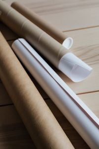 Kaboompics - Kraft Tubes with White End Caps and Rolled Paper on a Light Wood Table