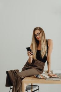 Kaboompics - Woman Holding Phone While Sitting at Table