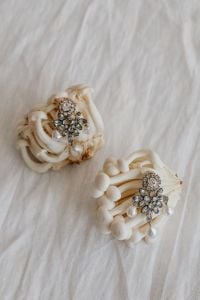 Kaboompics - White Mushrooms with Jeweled Brooches on White Fabric