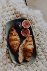 Kaboompics - Overhead Croissants and Halved Fresh Figs on a Green Ceramic Plate, Cozy Breakfast in Bed Macro