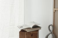 Kaboompics - Minimalist Reading Nook with Open Book, Sculpture and Sheer Curtain