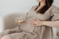 Kaboompics - Pregnant Woman Sitting on Sofa with Lemon Water