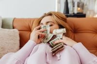 Kaboompics - Woman Lying on a Sofa with Dollar Bills