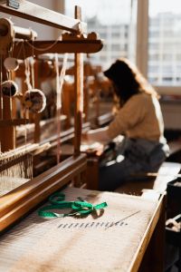 Woman Weaving on a Loom with Colorful Yarn