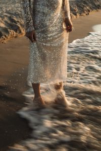 Kaboompics - Barefoot Woman in Sequin Dress Walking Through Waves