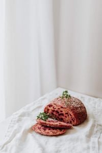 Kaboompics - Halved Beetroot Bread with Slices on Linen Cloth