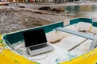 Kaboompics - MacBook Laptop in a Boat on a Pebble Beach, Wide Landscape