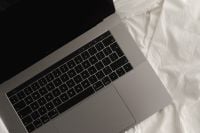 Kaboompics - Close-Up Laptop Keyboard and Trackpad on White Bed Linen