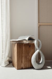 Kaboompics - Wooden Pedestal with Open Book and Textured Sculpture in Minimalist Interior