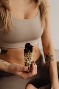 Kaboompics - Close-Up of Woman Holding a Smoldering Sage Bundle at Her Waist