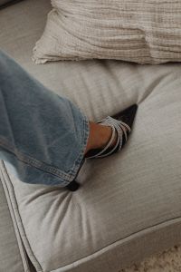 Kaboompics - Embellished Black Heels and Denim Styled on Light Upholstery