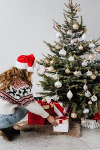 Kaboompics - Woman in Santa Hat Arranging Gifts by a Christmas Tree