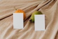 Kaboompics - Pear and Orange Fruit beside Two Blank Business Cards on Beige Fabric