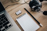 Kaboompics - Macbook pro with headphones and a notepad on a wooden desk