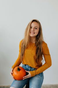 Kaboompics - Young Woman Holding Pumpkin at Waist