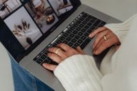 Kaboompics - Faceless Woman in White Sweater Typing on Laptop with Gold Rings