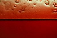Kaboompics - Red Glass Surface With Water Droplets Minimal Background