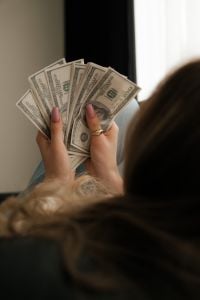 Kaboompics - Over the Shoulder View of Woman Holding Dollar Bills