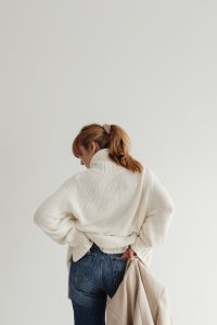 Kaboompics - Faceless Woman in White Sweater Adjusting Beige Coat