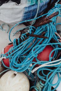 Kaboompics - Close-Up of Blue Fishing Net, Rope and Red Buoys on Sandy Beach