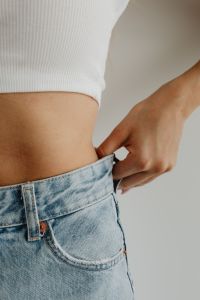 Kaboompics - White Ribbed Tank Top and Bare Arm with Light Blue Jeans, Minimal Fashion Close-Up