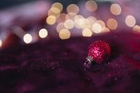 Kaboompics - Burgundy Christmas Background with Single Glitter Ornament and Gold Bokeh