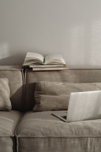 Kaboompics - Laptop and Open Planner on a Neutral Sofa with Blank Wall Copy Space