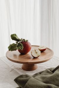 Kaboompics - Whole Red Apple with Dried Leaves and Fresh Apple Slices on a Round Wooden Tray