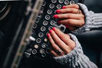 Kaboompics - Woman typing on an old typewriter