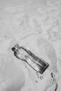 Kaboompics - Black and White Glass Bottle on the Sand