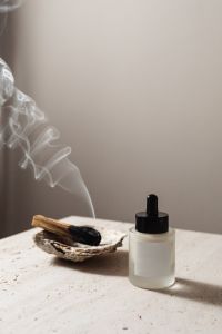 Kaboompics - Serum Bottle and Incense Smoke Still Life with Copy Space for Skincare Branding